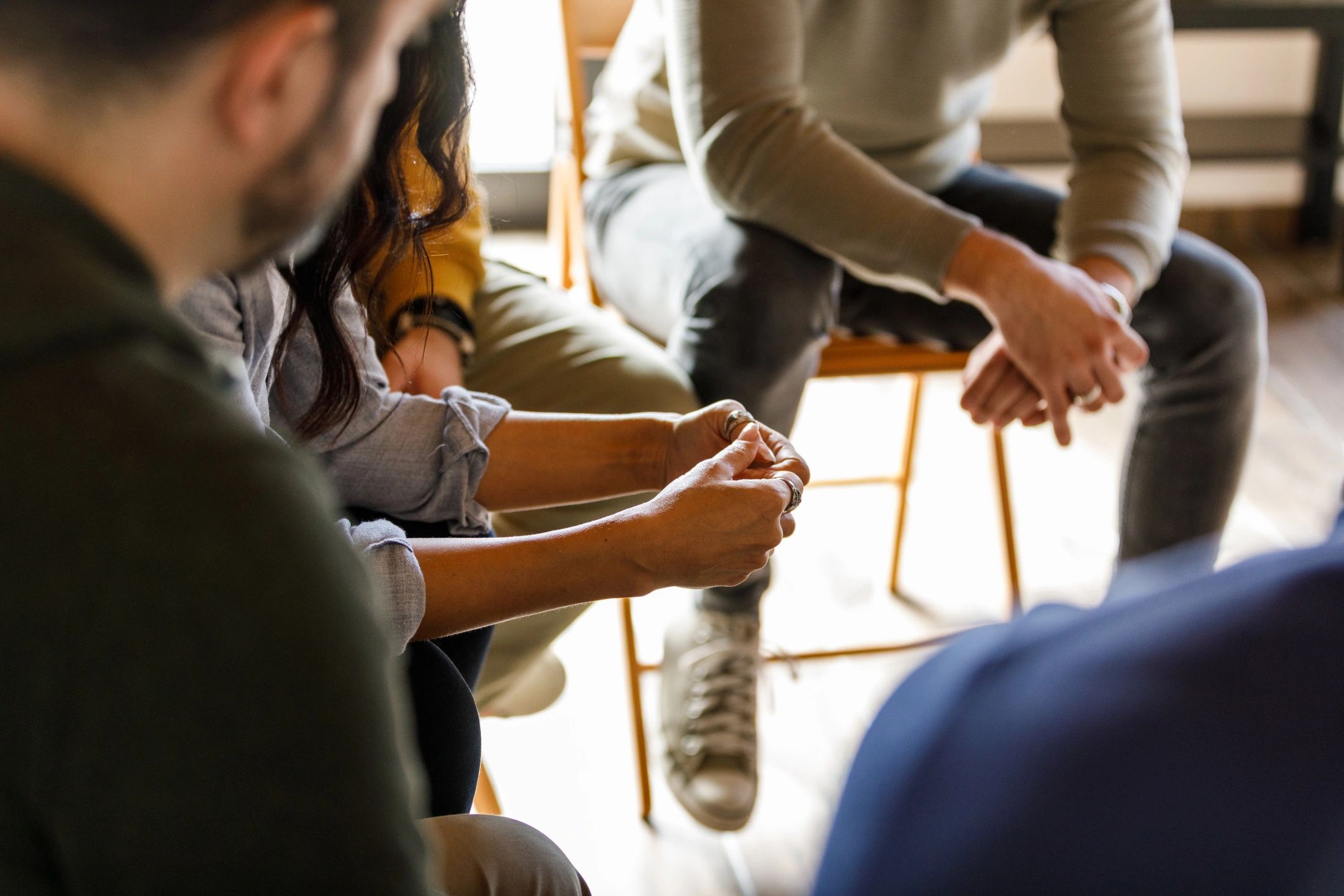 Hands fidgeting during a support group session, representing healing and support