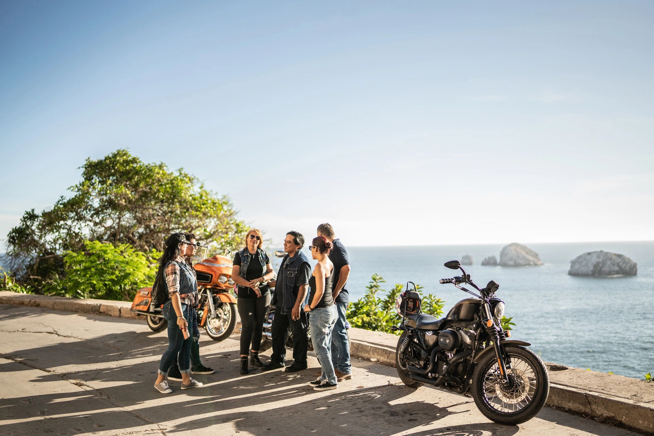 Friends talking during a motorcycle road trip stop